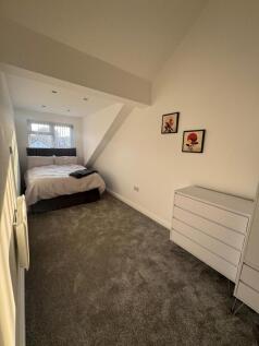 A bright double bedroom featuring a comfortable...