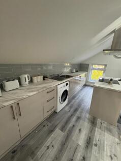 A modern kitchen with sleek cabinetry and marbl...