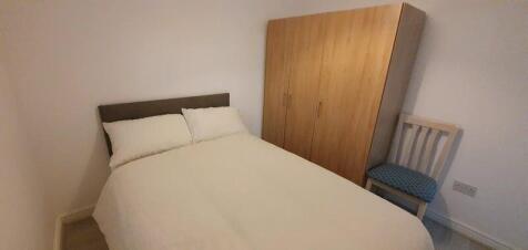 A cozy double bedroom featuring a neatly made b...
