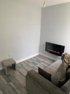 Cozy living room featuring a modern electric fi...