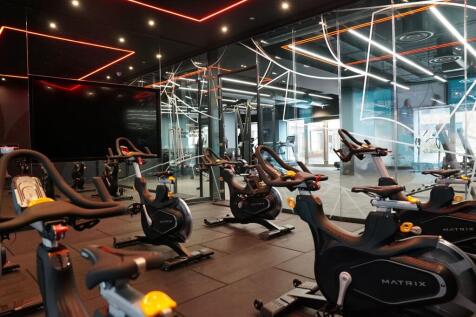 Modern gym space featuring multiple stationary ...
