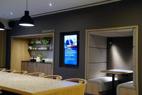 A modern communal lounge with a long speckled c...