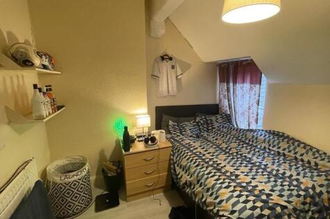 A neat and compact bedroom with a cozy single b...