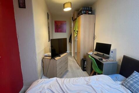 Cozy single bedroom featuring a comfortable bed...