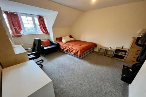 A spacious and tidy master bedroom featuring a ...