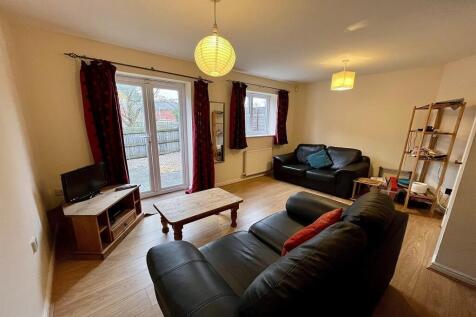 A cozy living room featuring two black leather ...