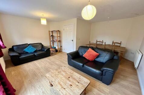 A welcoming living room featuring two black lea...