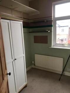 A modest single bedroom featuring a large windo...