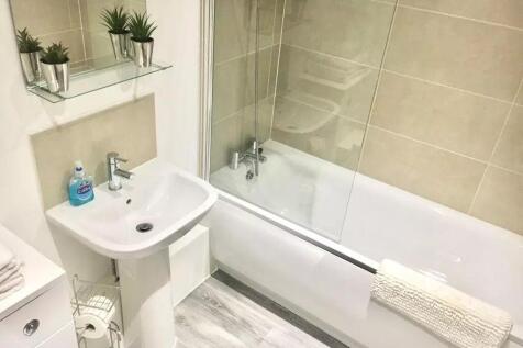 Bright and modern bathroom suite featuring a cl...