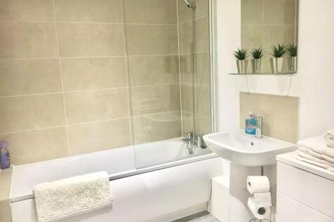 Bright and clean bathroom suite featuring a mod...