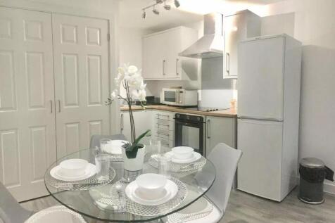 Bright and modern kitchen featuring a glass din...