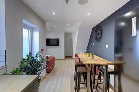 A modern communal lounge featuring a sleek wood...
