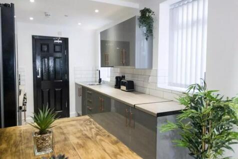 A modern kitchen featuring sleek grey cabinets ...