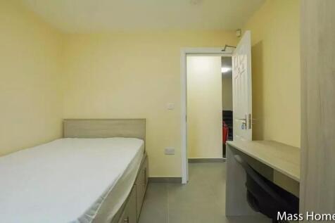 A neat and tidy single bedroom featuring a comf...