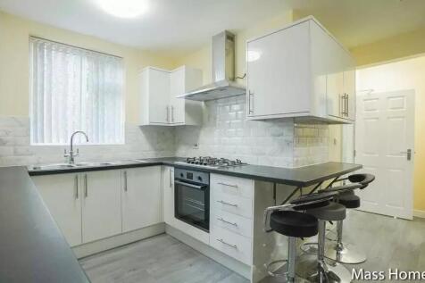 Bright and modern kitchen featuring sleek white...