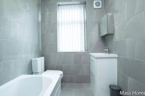 A modern bathroom suite featuring sleek grey ti...