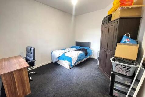 A modestly sized single bedroom featuring a com...