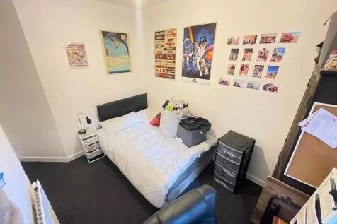 Cozy bedroom featuring a neatly made single bed...