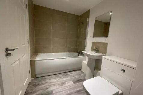 A modern bathroom suite featuring a clean, whit...