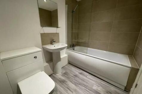 A modern bathroom suite featuring a clean white...