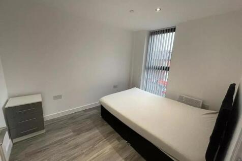 A bright and tidy single bedroom featuring mode...