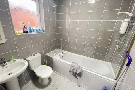 A modern bathroom suite featuring a clean white...