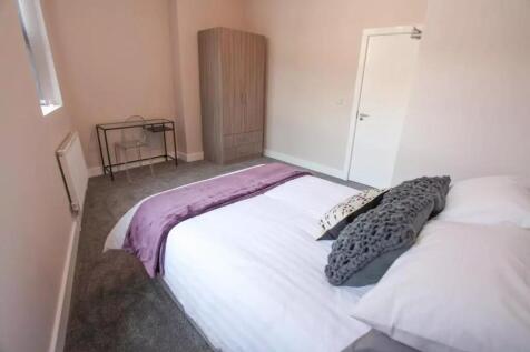 A bright and tidy master bedroom featuring a co...