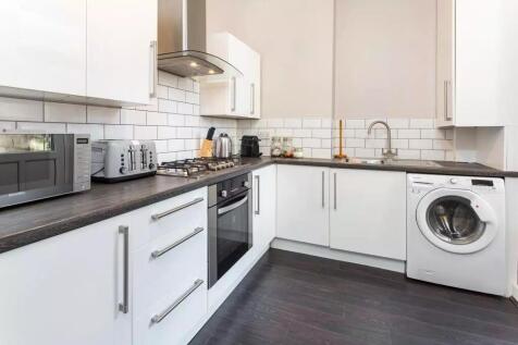 A modern kitchen featuring sleek white cabinetr...