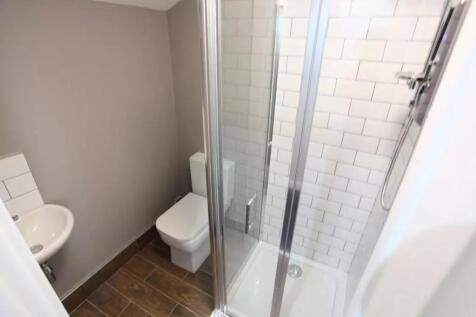 A modern and tidy bathroom featuring a glass-en...