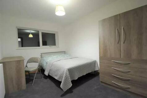 A tidy and simple double bedroom featuring a do...