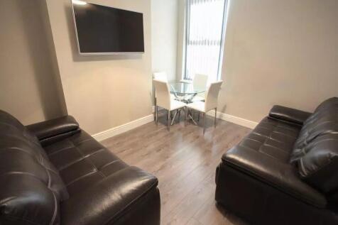 A modern living room featuring two black leathe...