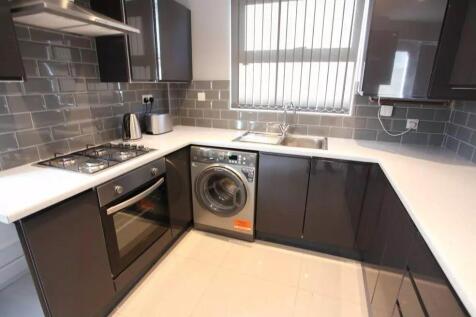 Modern kitchen featuring sleek black cabinets c...