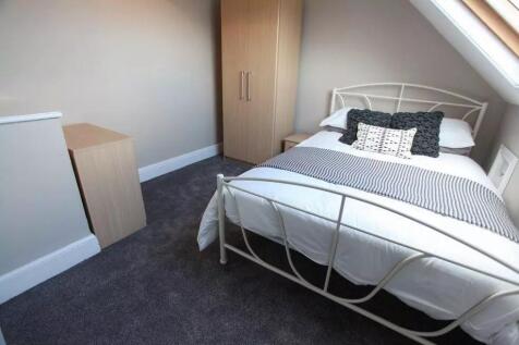 A cozy double bedroom featuring a neatly made b...