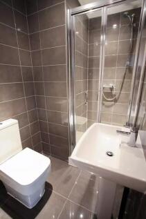 Modern bathroom featuring a sleek white toilet,...