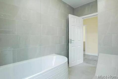A modern bathroom suite featuring a large white...