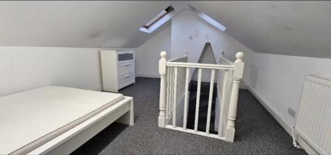 Bright attic bedroom featuring a clean, modern ...