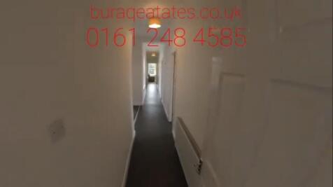 A long, narrow hallway with clean white walls a...