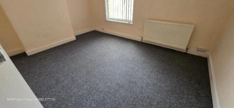 A simple, clean single bedroom with neutral wal...