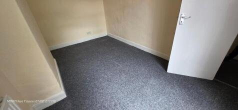 A clean, freshly carpeted room featuring neutra...