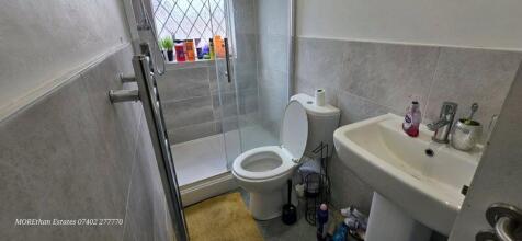 A clean and modern bathroom featuring a walk-in...