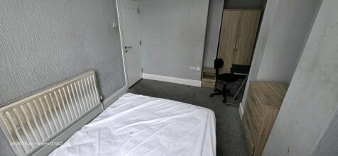 A simple room setup featuring a single bed with...