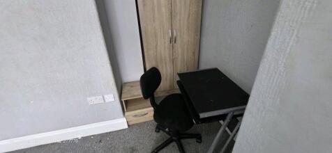 Compact study area with a black office chair, a...