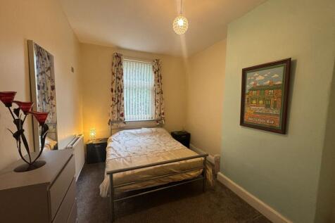 A cozy double bedroom featuring a metal frame b...