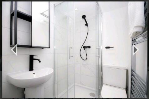 A modern and sleek bathroom featuring a glass-e...