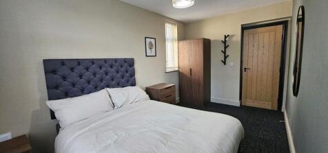 A clean and well-kept double bedroom featuring ...