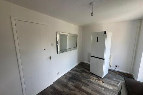 A clean, modern kitchen space featuring wood-ef...