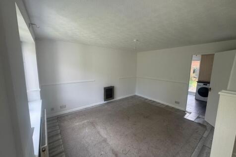 A spacious living room with large windows provi...