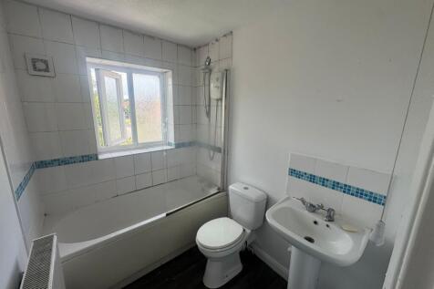 Bright and clean bathroom featuring a white bat...