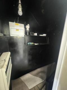 Compact storage space with dark walls and a sma...