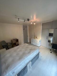 A bright double bedroom featuring a large bed, ...